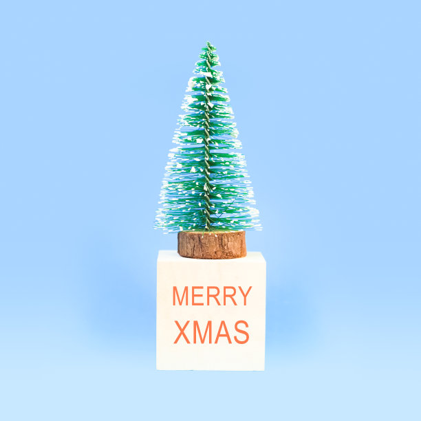 圣诞树上的立方体与文本圣诞快乐的蓝色背景。迷你圣诞和新年贺卡图片下载