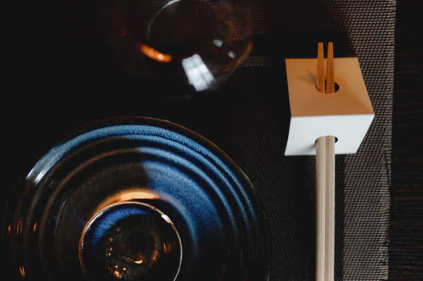 特写寿司餐厅餐桌设置与盘子，碗，玻璃和筷子与复制空间在纸板上。图片下载