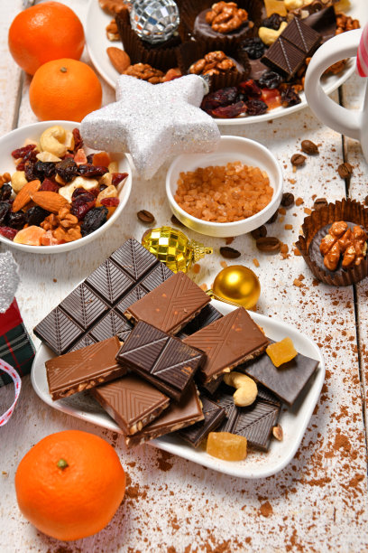甜蜜的食物俯视图背景为快乐的圣诞节或新年节日装饰-巧克力糖果，橘子，饼干在白色的木头图片下载