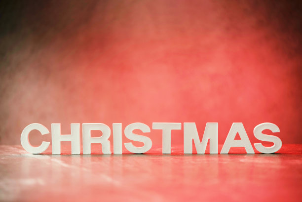 圣诞字由红色灯光背景上的白色混凝土字母组成。复制空间为您的创意设计。节日请柬、贺卡图片下载