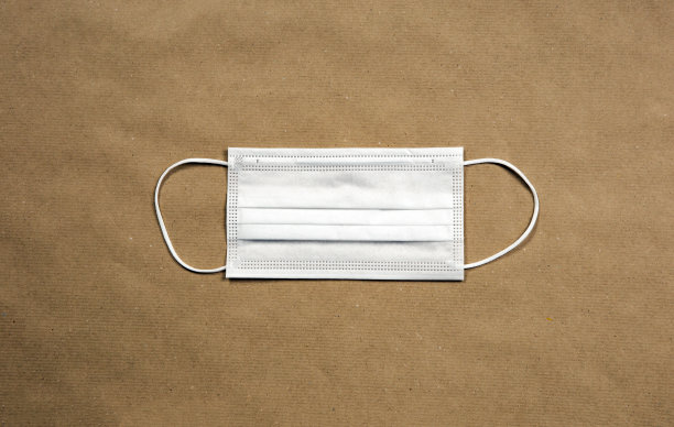 白色防护医用口罩用于冠状病毒、Covid-19等疾病，顶视图背景纹理牛皮纸，复制空间或文本空间的现代设计图片下载