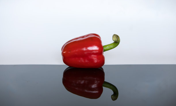 红色甜甜椒孤立和反射在黑色玻璃表面图片下载