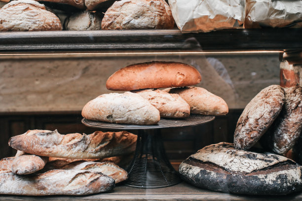 美味的新鲜烤法棍面包在一个面包房的窗台与其他面包。图为市场上的面包面包法棍图片下载