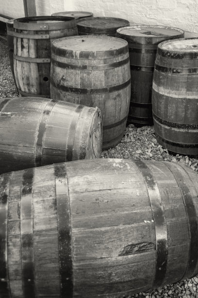 一群放在外面任凭风吹雨打的老威士忌酒桶。图片下载
