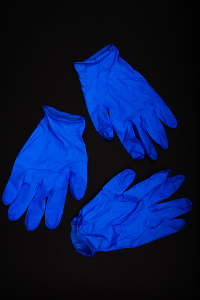黑色背景上的蓝色橡胶手套图片下载
