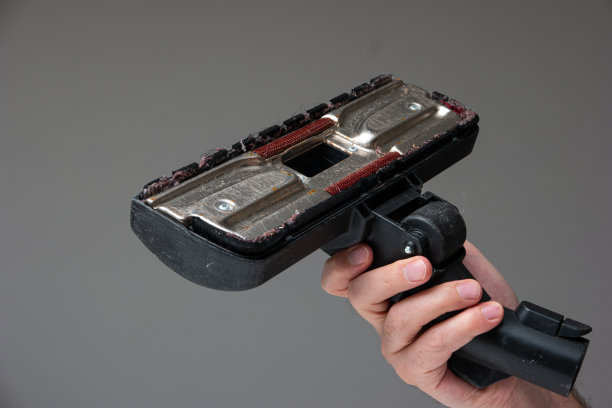 白人男性的手拿着一个旧的用肮脏的吸尘器刷附件与头发和灰尘近距离拍摄孤立的射线背景图片下载