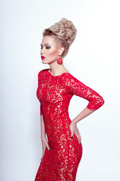 一个性感的年轻女子的侧面肖像，闭上眼睛，在白色的背景，红色的裙子和配件，摆出双手合十的姿势。图片下载