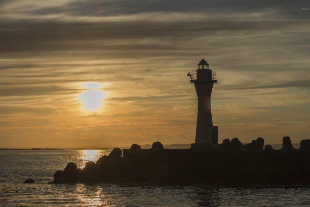 钏路港灯塔的剪影投射在日落时的橙色天空中图片下载