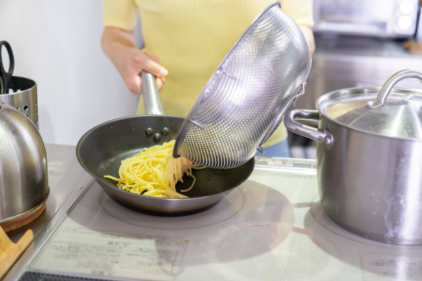 亚洲女人在厨房里做饭，意大利面，手图片下载