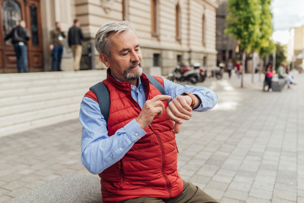 一位老人在街上等待某人并查看时间的肖像图片下载