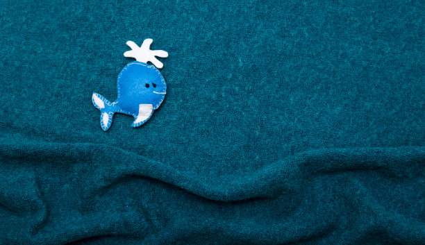 布制背景中的玩具鲸鱼。本空间图片下载