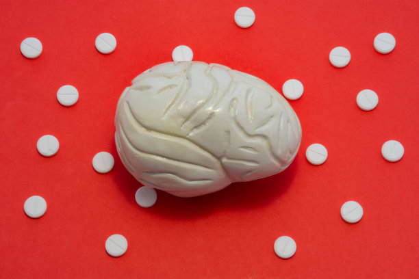 红色背景上的大脑解剖图，周围环绕着药片。缺血性或出血性中风、出血、动脉瘤破裂、外伤和血肿的神经学概念照片图片下载