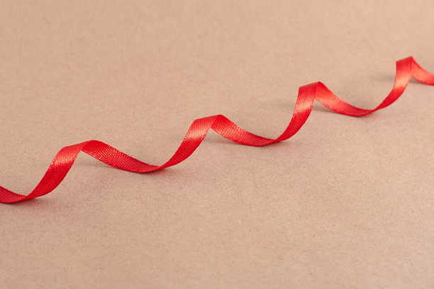 波浪红丝带，牛皮纸背景。牛皮纸质地。图片下载