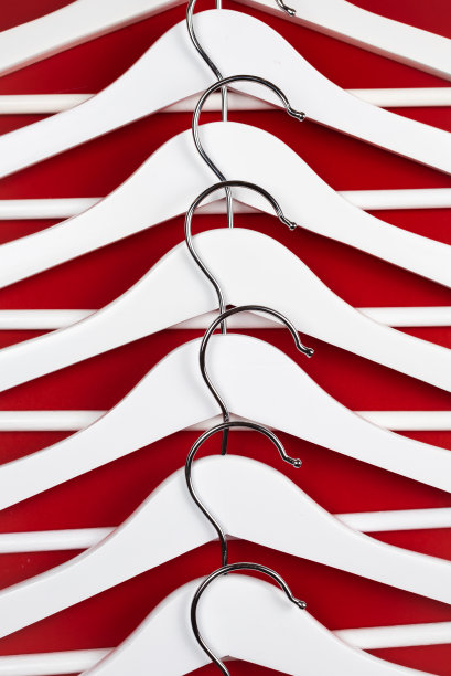 红色背景上的白色衣架。销售服装的概念。图片下载