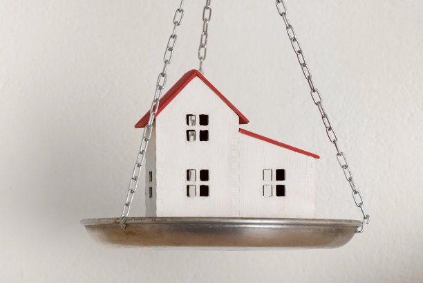 房子模型的天平。购买新房或房产图片下载
