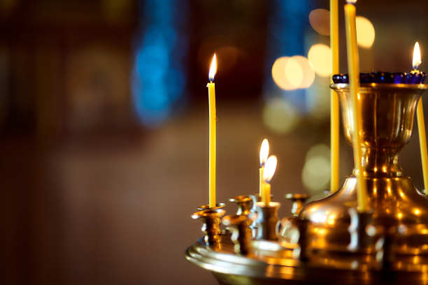 古老的教堂里插着许多黄色的蜡烛。基督教。燃烧的蜡烛。宏观效果的照片。特写镜头图片下载