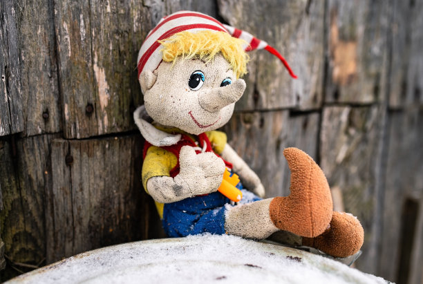 被遗弃的脏兮兮的旧玩具笑了，尽管情况很悲惨。孤独和无用的概念。图片下载