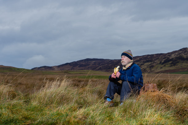 一位老人独自坐在苏格兰西南部一个阴天的偏僻地方图片下载