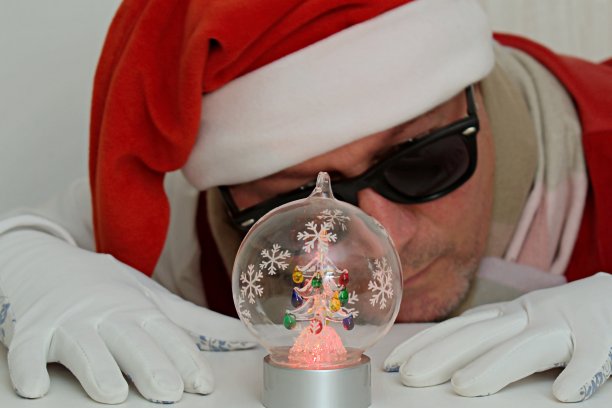 圣诞球里面的桌子上有灯和模糊的背景睡觉的男人图片下载