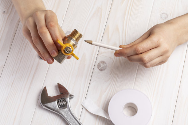 女水管工演示了带有外螺纹(外螺纹)的气体旋塞。图片下载