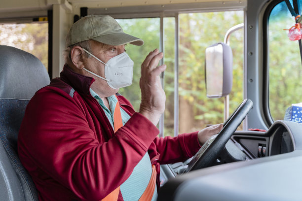 老人，因新冠肺炎疫情戴着n95防护口罩的公交车司机，在农村地区驾驶校车。图片下载