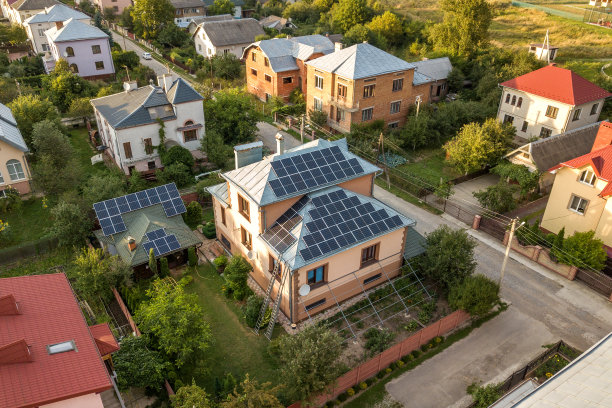 新现代住宅别墅的空中俯瞰，屋顶上有蓝色闪亮的太阳能光伏电池板系统。可再生生态绿色能源生产理念。图片下载