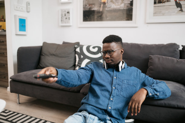 年轻的非洲裔美国人在家里看电视图片下载