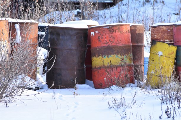 雪地里五颜六色的风化钢桶。图片下载