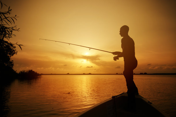 湖边船上一个男人的剪影图片下载