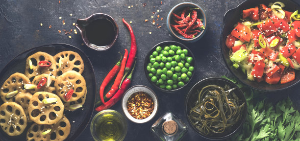 亚洲晚餐的横幅，以亚洲风格的食材:莲藕或根茎、绿豌豆、海藻、炒菜、香料和不同类型的辣椒放在黑色的乡村石头上图片下载