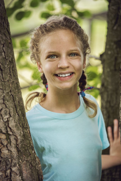 一个年轻美丽的女孩在森林里玩耍图片下载