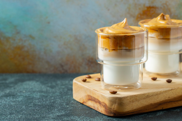 Dalgona咖啡。冰，蓬松，奶油，混合咖啡泡沫和牛奶。时兴饮品2019冠状病毒病期间城市封锁和自我隔离，待在家里的理念。与复制空间素材图片