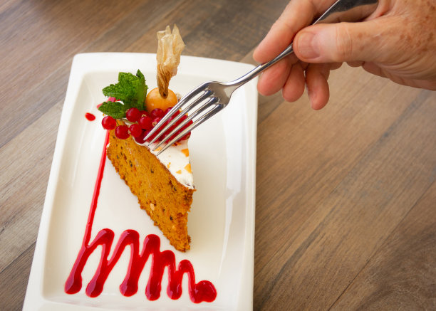 叉子拿着胡萝卜糖霜蛋糕图片下载