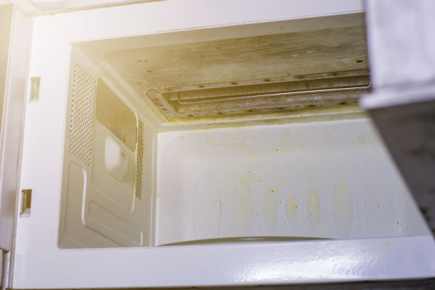 肮脏的微波。墙上有烧焦的油漆图片下载