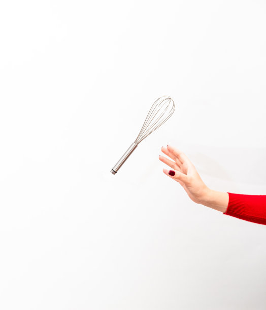 一只修指甲的手抓住一个打蛋器，准备做甜点。图片下载