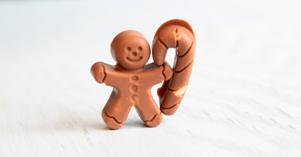 白色背景上的一个小个子男人的圣诞巧克力。有选择性的重点。图片下载