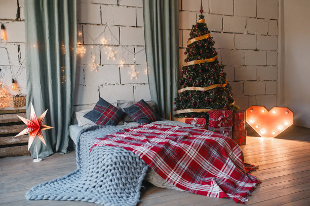 舒适，舒适，室内和假日概念-舒适的白色阁楼卧室与床和圣诞花环灯和树在家里图片下载