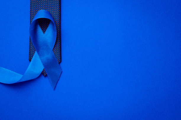 癌症的认识蓝色。蓝色丝带，时尚领带，深蓝色背景。11月认识前列腺癌对男性健康的影响。11月和国际男人日。图片下载