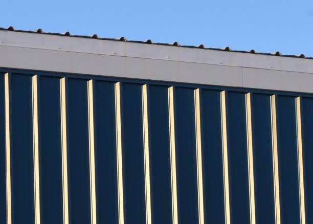 蓝色、银色和白色的金属建筑映衬着蓝天。图片下载