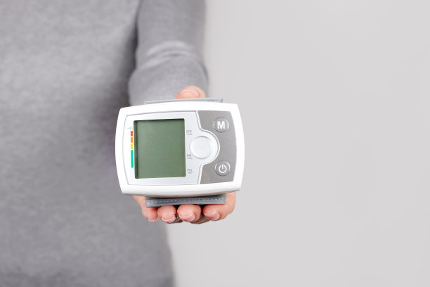 手持灰色背景下的医疗压力监测仪。图片下载