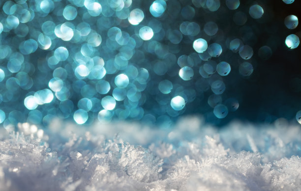 假日背景与白色的雪晶体和明亮的蓝色火花和圆圈图片下载