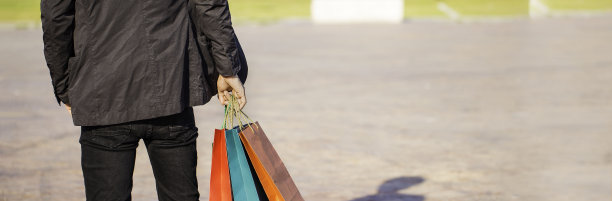 横幅背景的年轻人穿着西装拿着购物袋图片下载