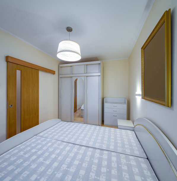 公寓卧室的现代内饰。白色的家具。滑动木门。衣柜的镜子。图片下载