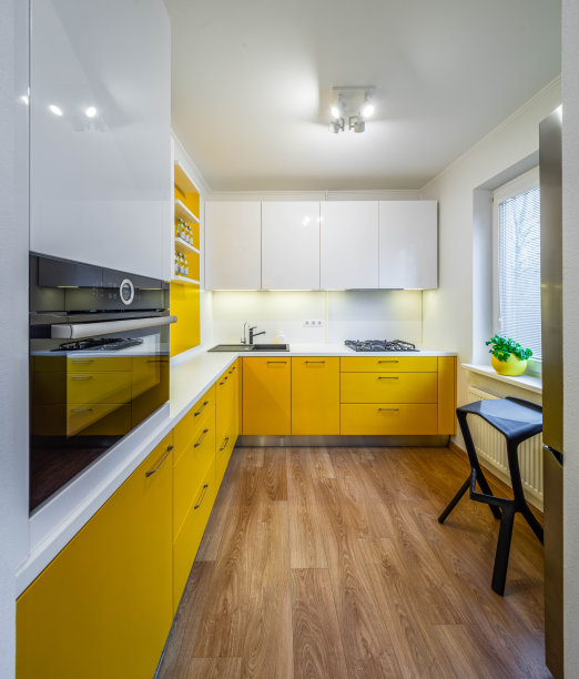 现代室内厨房在豪华公寓。黄色的厨房和白色的柜台。黑沉。煤气炉。烤箱。橱柜和抽屉。图片下载