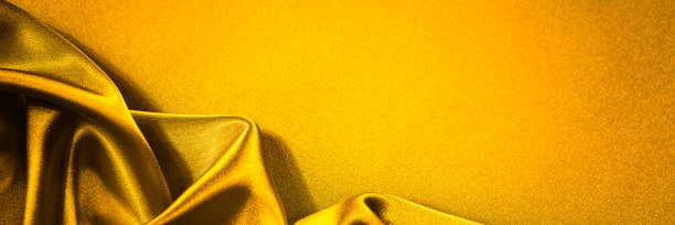 桔黄色的织物背景。有柔软波浪褶的绸缎。图片下载