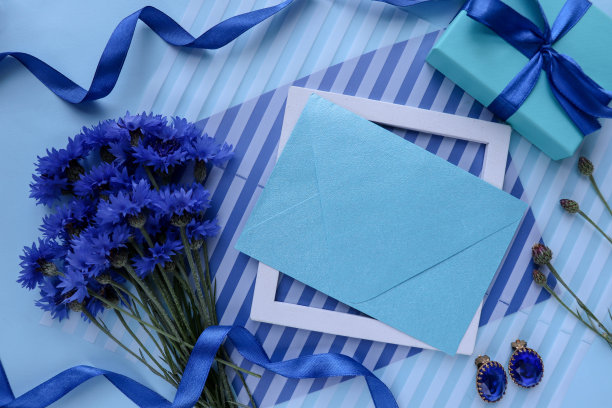 一束白色背景的蓝色矢车菊和一个信封图片下载