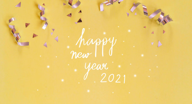 特写“新年快乐2021”书法手写与一组银色滚动彩带和五彩纸屑在黄色的背景，为节日，嘉年华和周年，概念设计图片下载