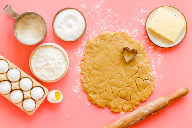 用擀面杖擀面团。心形的饼干切出来。俯视图图片下载