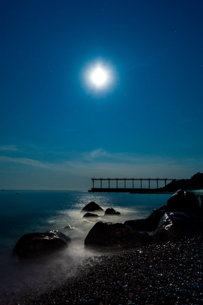 月亮越过大海和石头海岸图片下载