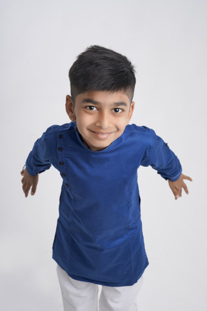 可爱的印度小男孩穿着民族服装，在白色背景上表现出表情图片下载